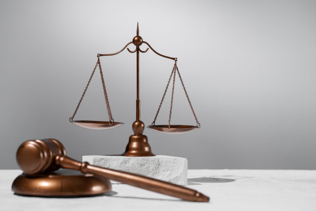 Imagem de destaque com uma balança da justiça ao lado de um martelo de juiz, simbolizando decisões judiciais e equilíbrio em questões financeiras como conta penhorada